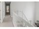 Hallway featuring a white staircase, carpet, and an open view of the home's interior at 1439 Alice Ave, Lithonia, GA 30058