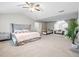 Spacious main bedroom with sitting area, neutral carpet, and modern ceiling fan at 1439 Alice Ave, Lithonia, GA 30058