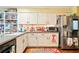 Efficient kitchen with white cabinets, stainless steel appliances, and functional layout at 1825 Crescent Rdg, Cumming, GA 30041