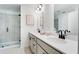 Modern bathroom featuring double sinks with black fixtures, white cabinets and a tiled glass door shower at 6236 Kenbrook Dr, Tucker, GA 30084