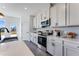 Bright, modern kitchen with white cabinets, quartz countertops and stainless steel appliances at 6236 Kenbrook Dr, Tucker, GA 30084