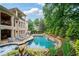 A gorgeous backyard pool features waterfall and lounge seating at 8109 Lawnview, Alpharetta, GA 30022