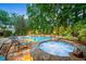 Beautiful backyard featuring a luxurious pool, spa, and ample lounge space surrounded by greenery at 8109 Lawnview, Alpharetta, GA 30022