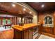 An elegant bar area featuring a wooden countertop, custom cabinets, and a view of the game room for entertainment at 8109 Lawnview, Alpharetta, GA 30022