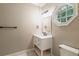 Bathroom featuring a single sink vanity, octagonal window, and tiled flooring at 8109 Lawnview, Alpharetta, GA 30022