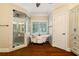 Bright bathroom featuring a clawfoot tub, glass enclosed shower, and wood look tile flooring at 8109 Lawnview, Alpharetta, GA 30022