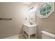 Bathroom featuring white vanity, hexagon window, white walls, and chrome fixtures at 8109 Lawnview, Alpharetta, GA 30022