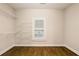 Walk-in closet featuring built-in shelves, hardwood flooring, and a window for natural light at 8109 Lawnview, Alpharetta, GA 30022