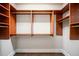 A walk-in closet with custom built-in wooden shelves and drawers for optimal storage and organization at 8109 Lawnview, Alpharetta, GA 30022