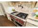 Stainless steel cooktop range with marble countertops and backsplash at 8109 Lawnview, Alpharetta, GA 30022