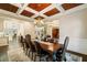 A formal dining room featuring wainscoting, coffered ceilings, and a stylish chandelier at 8109 Lawnview, Alpharetta, GA 30022