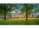 Beautiful home with lush front lawn and mature trees surrounding the property at 8109 Lawnview, Alpharetta, GA 30022