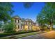 Stately two-story home with black shutters, manicured landscaping, and illuminated entry at 8109 Lawnview, Alpharetta, GA 30022