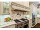 Close-up of a chef's kitchen with a professional-grade range and marble countertops at 8109 Lawnview, Alpharetta, GA 30022