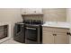 A bright laundry room with overhead storage, utility sink, and front load washer dryer units at 8109 Lawnview, Alpharetta, GA 30022