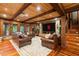 Living room featuring hardwood floors, wood paneling, a stone fireplace, and leather sofas at 8109 Lawnview, Alpharetta, GA 30022