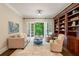 Cozy living room with a built-in bookcase, comfortable seating, and french doors to the outside at 8109 Lawnview, Alpharetta, GA 30022