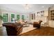 Bright living room with a fireplace, built-in shelving, large windows, and hardwood floors at 8109 Lawnview, Alpharetta, GA 30022