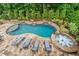 A stunning pool with a hot tub, surrounded by lush landscaping and stone accents, offers a private backyard oasis at 8109 Lawnview, Alpharetta, GA 30022