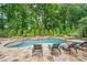 Relax by the pool with lounge chairs, enhanced by natural landscaping and a serene, wooded backdrop at 8109 Lawnview, Alpharetta, GA 30022
