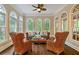 Cozy sunroom with wicker furniture and walls of windows offering panoramic views at 8109 Lawnview, Alpharetta, GA 30022