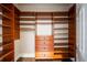 Well-organized walk-in closet with wooden shelves, drawers, and rods for hanging clothes, perfect for storage at 8109 Lawnview, Alpharetta, GA 30022