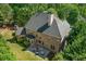 Aerial view of a brick house surrounded by trees, featuring a well-maintained lawn and cozy patio area at 8745 Islesworth Ct, Duluth, GA 30097