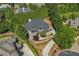 An aerial view showcases the lush landscaping and mature trees surrounding a beautiful brick home in a serene neighborhood at 8745 Islesworth Ct, Duluth, GA 30097