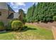 A neatly landscaped backyard with a retaining wall, mature trees, and green lawn, creating a serene outdoor space at 8745 Islesworth Ct, Duluth, GA 30097