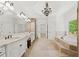 Bright bathroom with bathtub, shower, double vanity and view to the outside at 8745 Islesworth Ct, Duluth, GA 30097