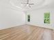 An expansive bedroom features a tray ceiling, hardwood floors and large windows at 8745 Islesworth Ct, Duluth, GA 30097