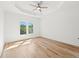 An expansive bedroom features a tray ceiling, hardwood floors and large windows at 8745 Islesworth Ct, Duluth, GA 30097