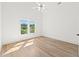 Light-filled bedroom with gleaming hardwood floors and a large window offering scenic outdoor views at 8745 Islesworth Ct, Duluth, GA 30097
