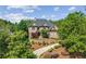 A well-maintained home surrounded by mature trees, complemented by professional landscaping and a curved driveway at 8745 Islesworth Ct, Duluth, GA 30097