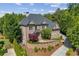 A brick home featuring mature trees, manicured landscaping, and a curved driveway enhancing its curb appeal at 8745 Islesworth Ct, Duluth, GA 30097