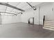 Immaculate garage with an epoxy floor, stairs to the main house, and stainless steel fridge at 8745 Islesworth Ct, Duluth, GA 30097