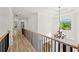 Hallway with wood floors, railing, chandelier, and natural light at 8745 Islesworth Ct, Duluth, GA 30097