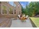 A cozy patio area with brick accents, comfortable seating, and mature trees, perfect for outdoor relaxation and entertaining at 8745 Islesworth Ct, Duluth, GA 30097