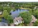 Stunning aerial view of home on lake with lush trees and landscaping at 9115 Nesbit Lakes Dr, Alpharetta, GA 30022