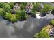 Aerial view of lakefront home surrounded by mature trees, on large lot at 9115 Nesbit Lakes Dr, Alpharetta, GA 30022