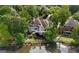 Aerial view of home with lake access and manicured backyard landscaping at 9115 Nesbit Lakes Dr, Alpharetta, GA 30022