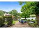 Scenic backyard with a stone patio seating area overlooking the serene lake and lush greenery at 9115 Nesbit Lakes Dr, Alpharetta, GA 30022
