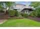 Backyard with a lush lawn, patio, white exterior, steps, and mature trees providing a park-like setting at 9115 Nesbit Lakes Dr, Alpharetta, GA 30022