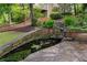 Backyard with stone pond and lush greenery, creating a tranquil outdoor space at 9115 Nesbit Lakes Dr, Alpharetta, GA 30022