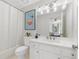 Bright bathroom features white vanity with marble countertop, tub and shower combo, and decorative wall art at 9115 Nesbit Lakes Dr, Alpharetta, GA 30022