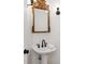 Elegant powder room with a pedestal sink, ornate mirror, and stylish lighting fixtures at 9115 Nesbit Lakes Dr, Alpharetta, GA 30022