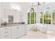 Elegant bathroom with large windows, a soaking tub, and a vanity with marble countertop at 9115 Nesbit Lakes Dr, Alpharetta, GA 30022