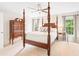 Bedroom with a four-poster bed, ceiling fan, side table with lamp, and chest of drawers at 9115 Nesbit Lakes Dr, Alpharetta, GA 30022
