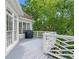 Exterior view of a gray wood deck with a white railing, offering an outdoor space surrounded by lush green trees at 9115 Nesbit Lakes Dr, Alpharetta, GA 30022