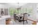 Bright dining area with stainless steel refrigerator, a modern light fixture, and many windows overlooking lush trees at 9115 Nesbit Lakes Dr, Alpharetta, GA 30022